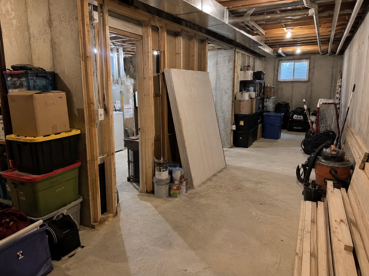 Cluttered unfinished basement used for storage before remodeling